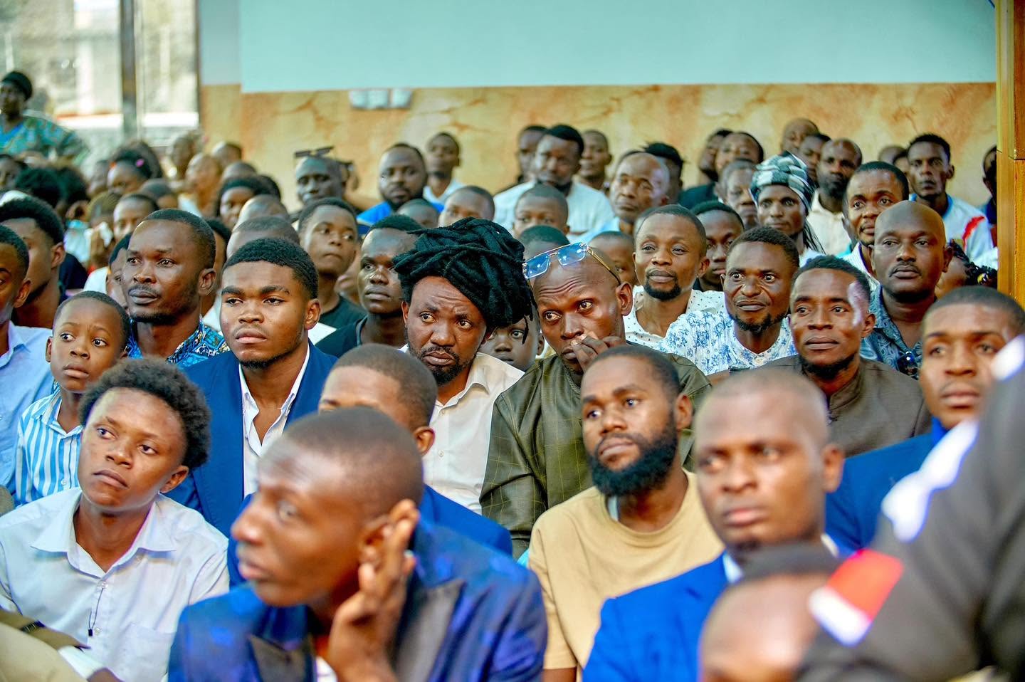 Hommes de l’assemblée à l’écoute lors d’un rassemblement Liloba